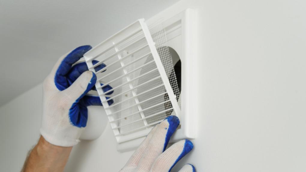 gloved hands puts back caravan vent